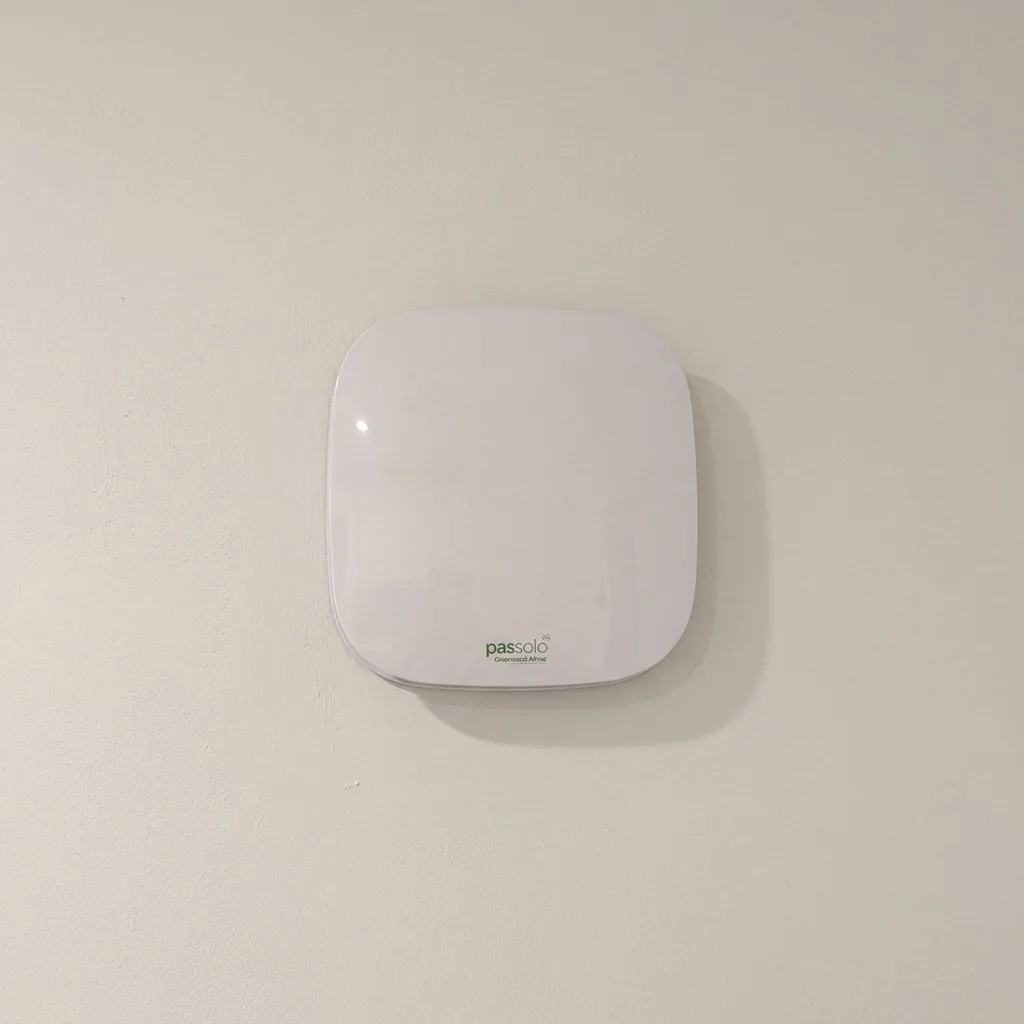 Completed sleek white continuous dMEV fan flush mounted on wall